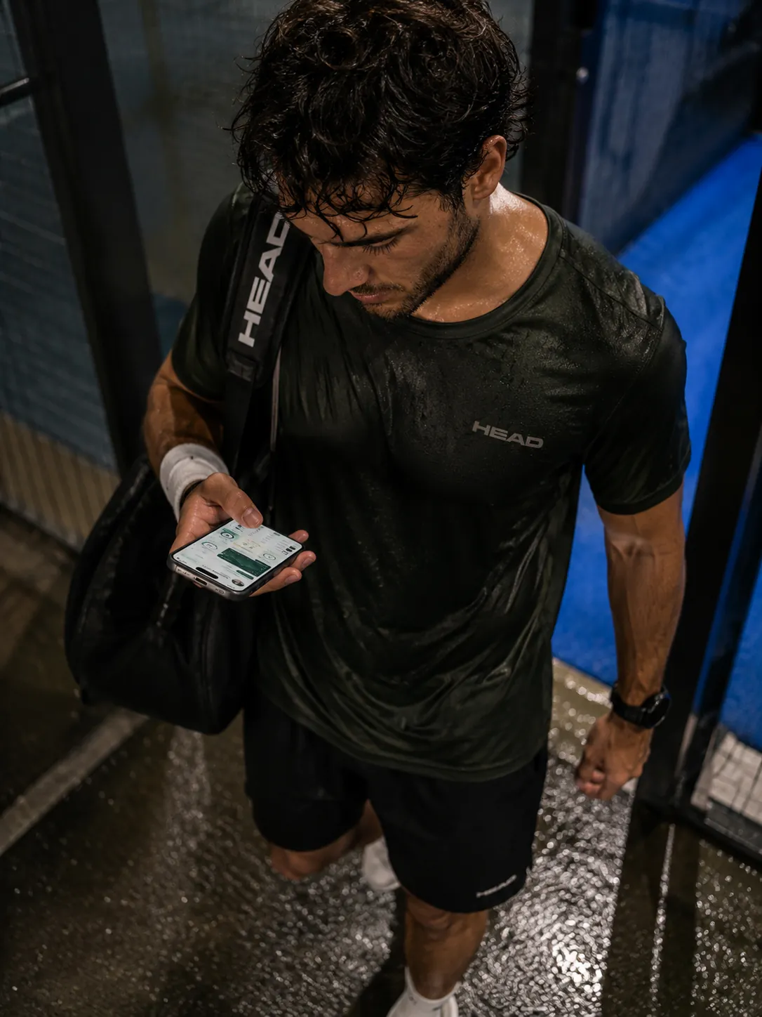 Giocatore di padel che controlla l’app del circolo dopo una partita